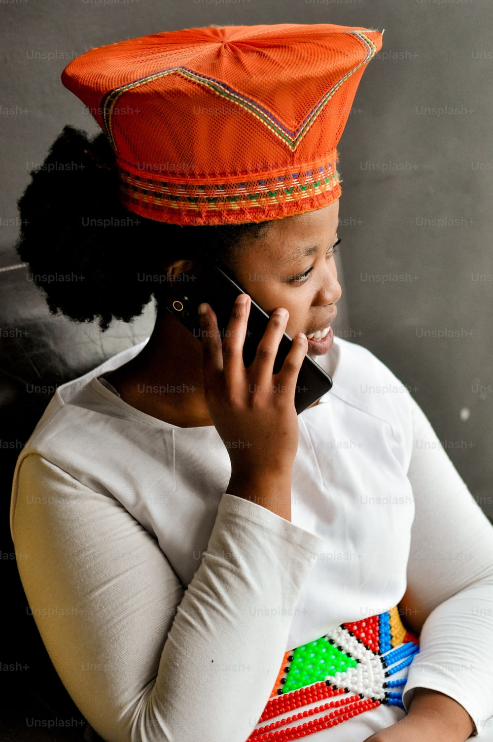 a woman wearing an orange hat talking on a cell phone