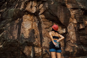 Eine Frau steht vor einem großen Felsen