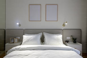 un lit blanc avec deux images encadrées au-dessus