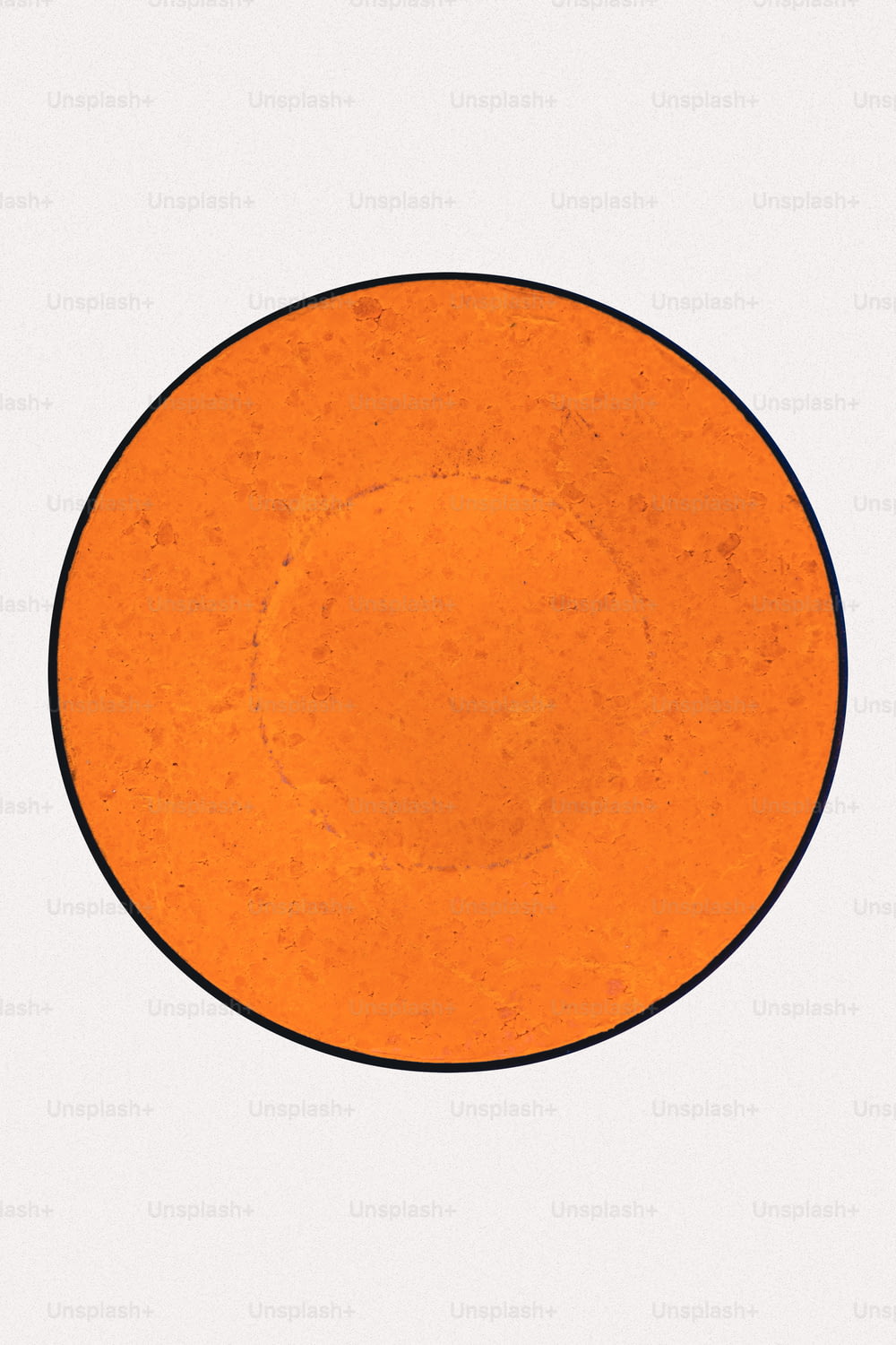 an orange plate with a black border on a white background