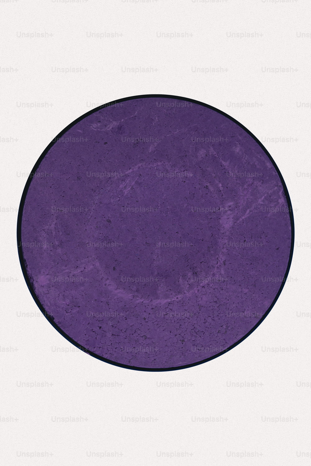a purple plate with a black rim on a white background