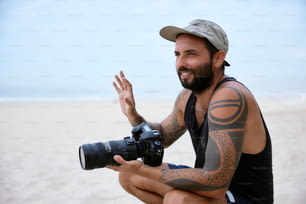 カメラを持ってビーチに座っている男性