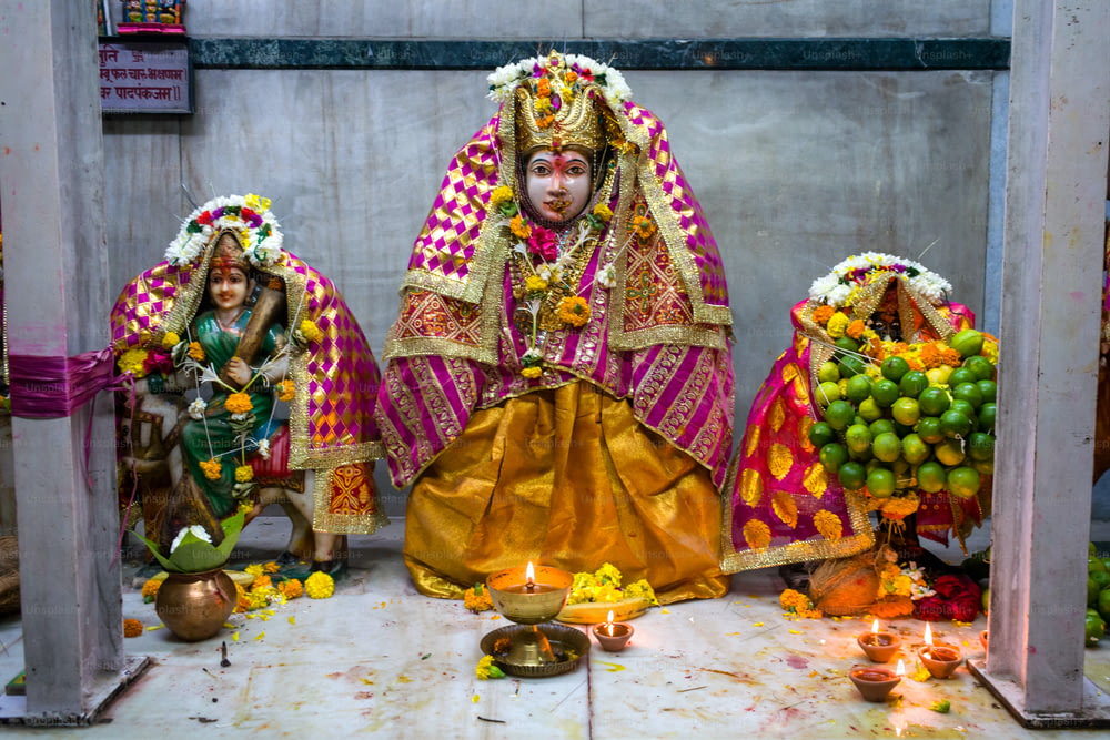 a statue of a woman in a colorful outfit surrounded by fruit