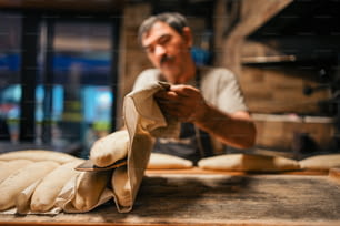 a man is making bread in a bakery