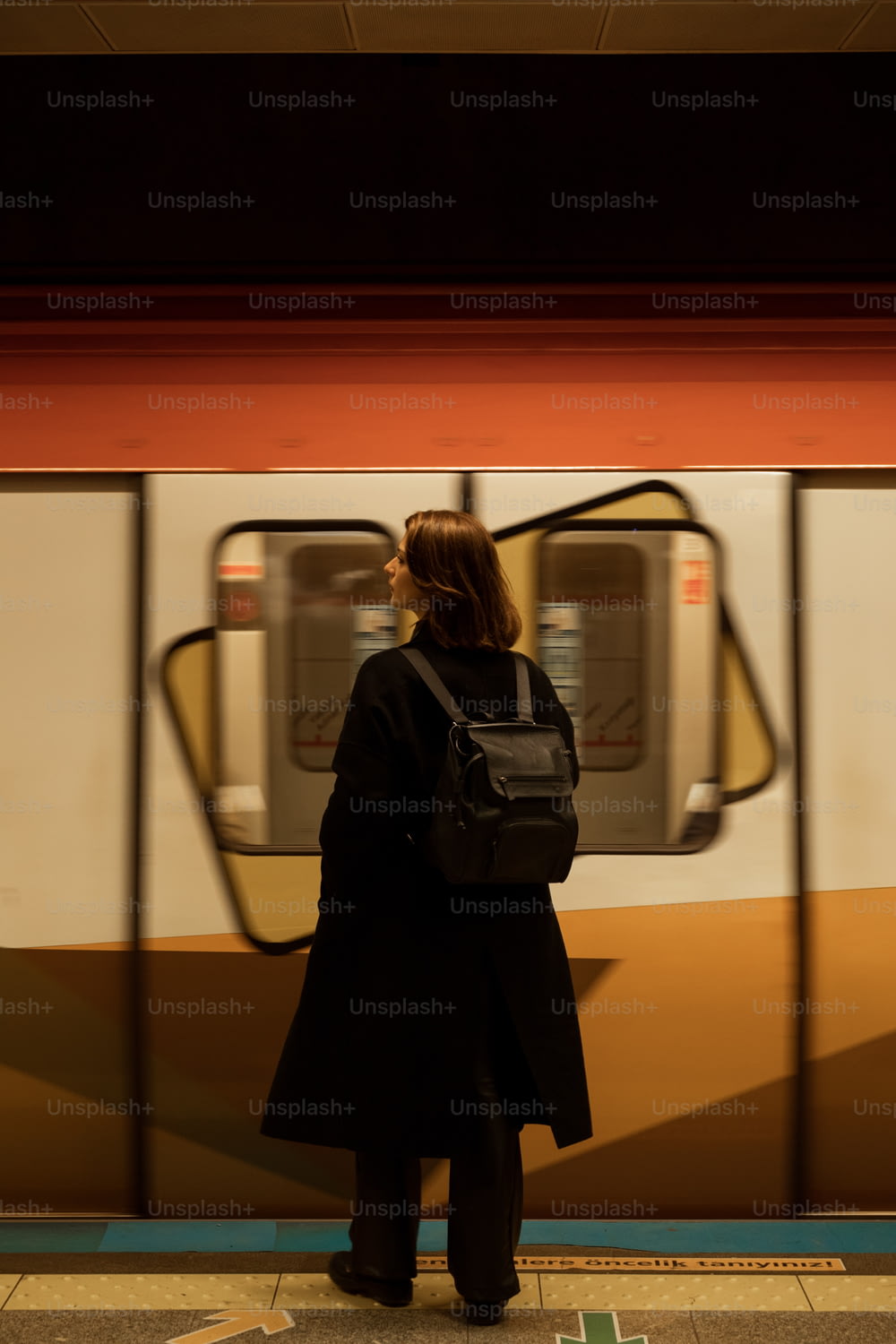 a woman waiting for a train at a subway station