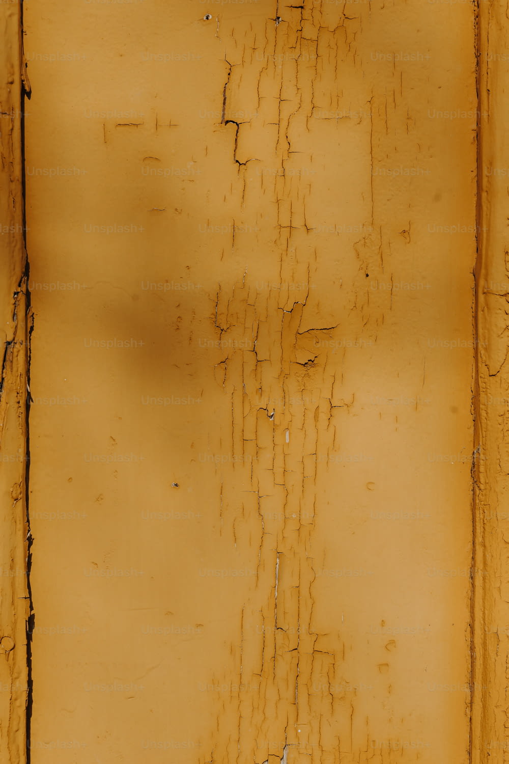 a yellow wall with peeling paint on it