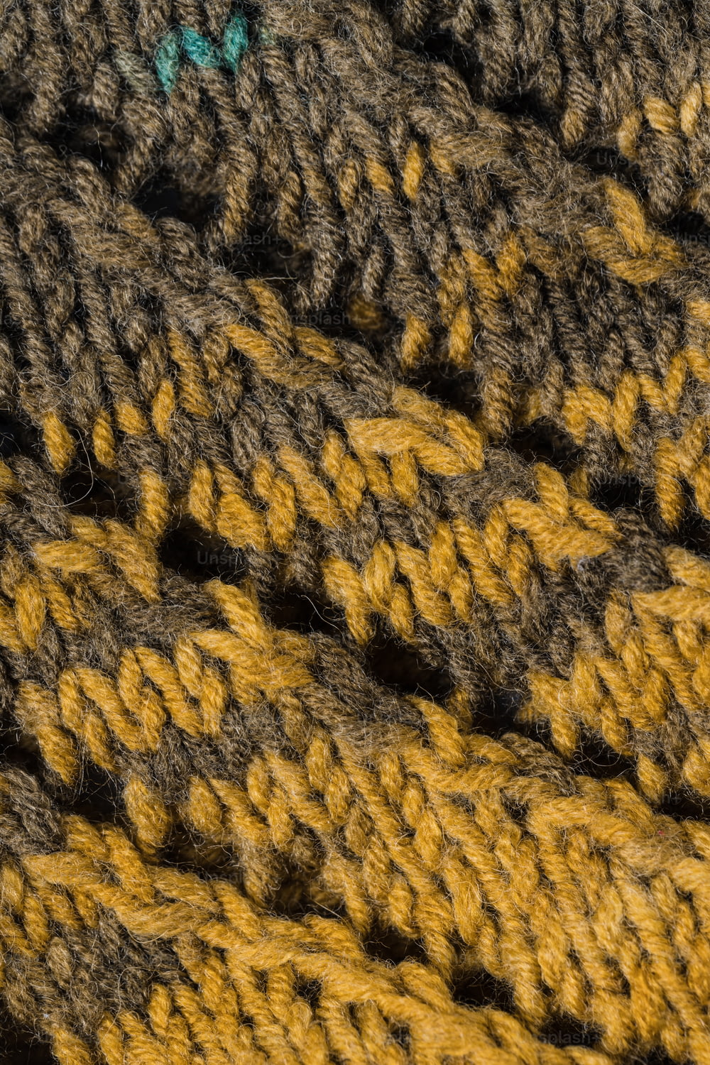 um close up de um cobertor de crochê com um botão verde