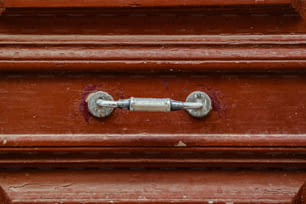 Un primer plano de una manija de metal en una puerta roja