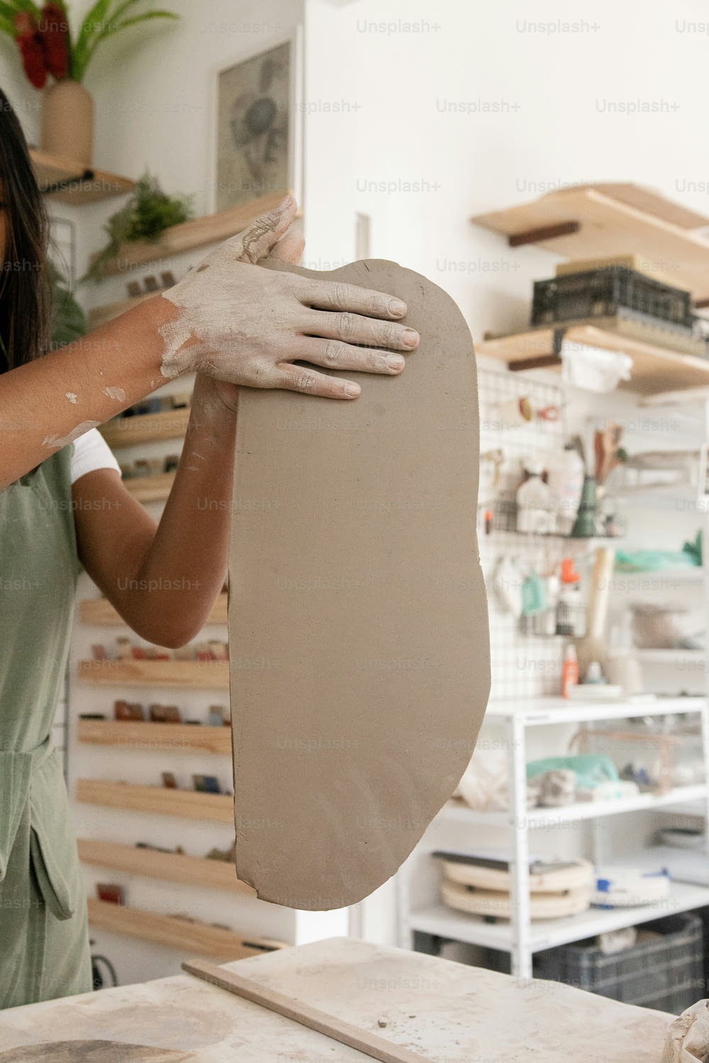 a woman is making a clay sculpture in a studio