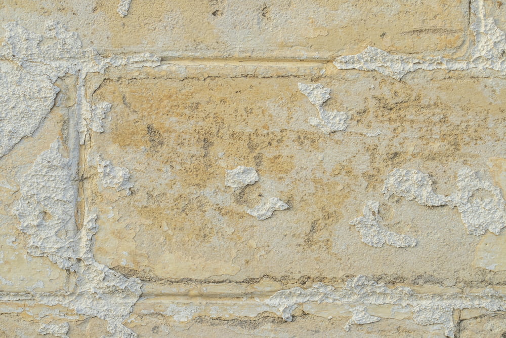Un primer plano de un muro de piedra con pintura descascarada
