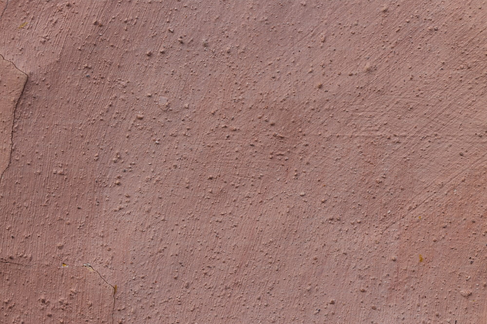 a close up of a red wall with small holes in it