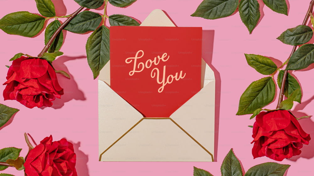 um envelope vermelho com um cartão de amor em cima dele