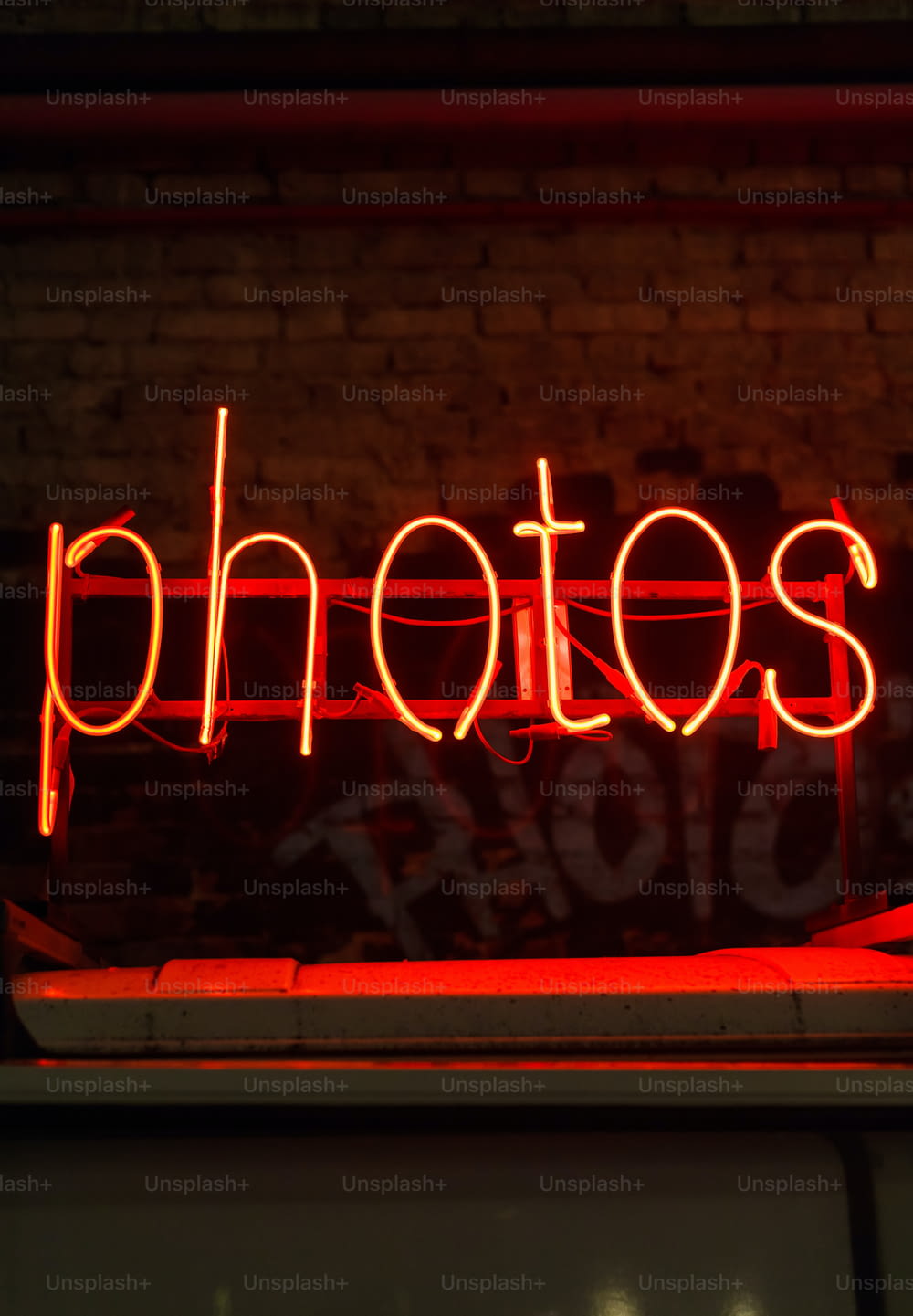 a red neon sign that says photos