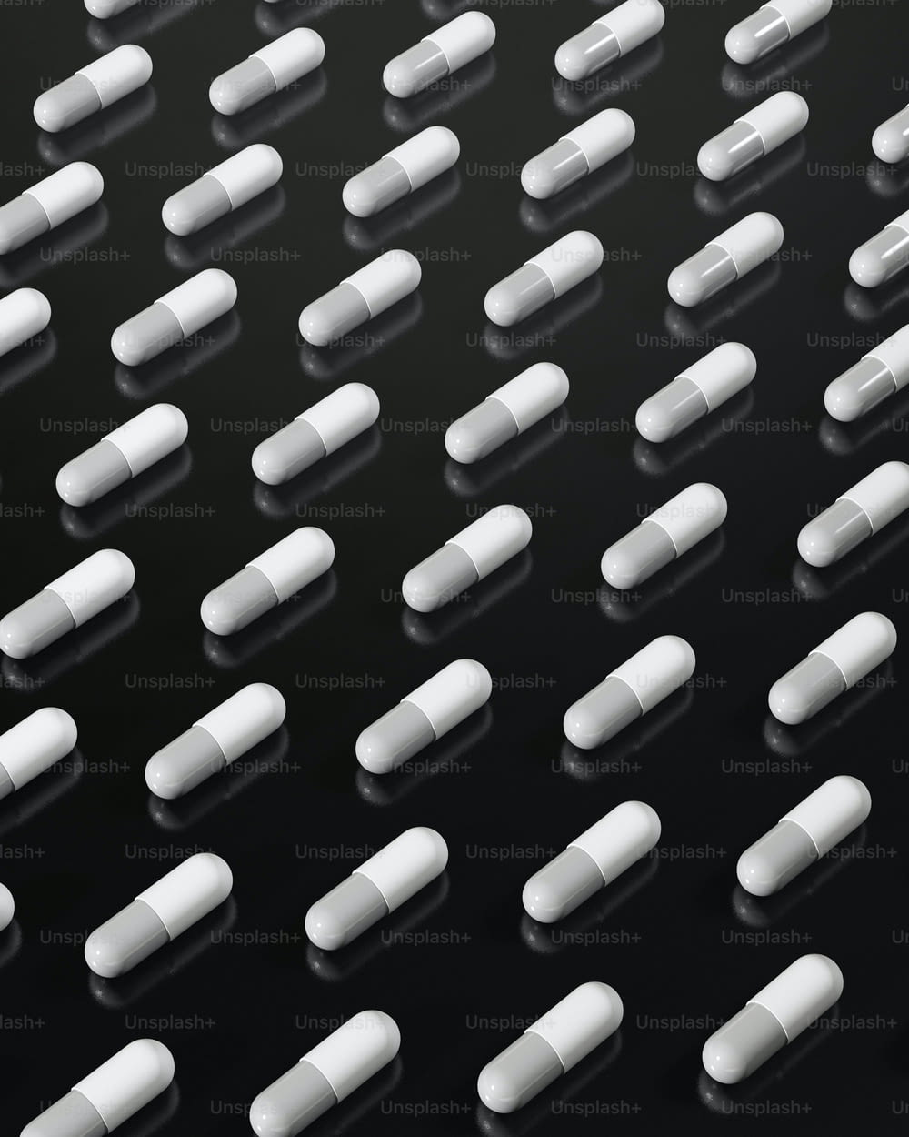 many white pills are arranged on a black surface