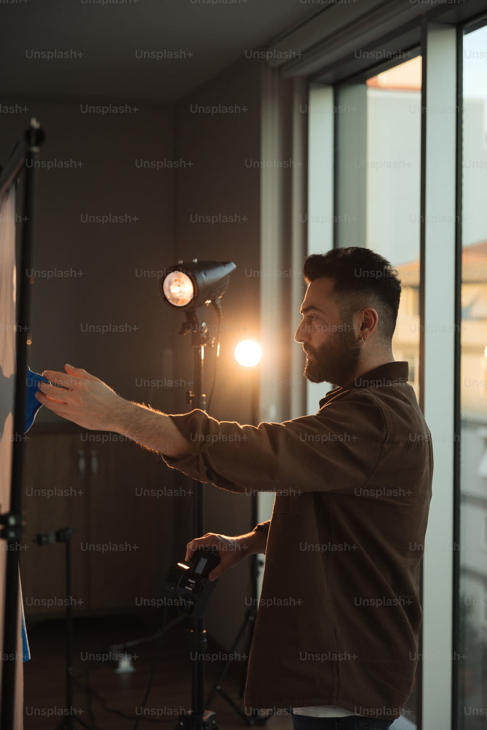 a man standing in front of a camera holding a light