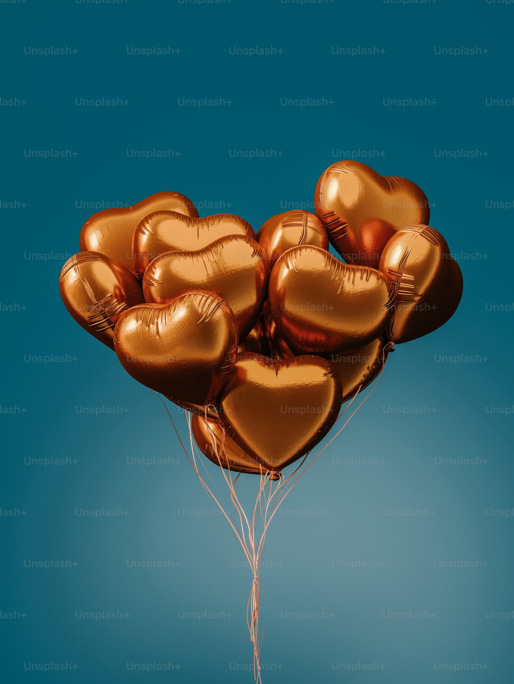 ein Haufen goldener herzförmiger Ballons, die in der Luft schweben