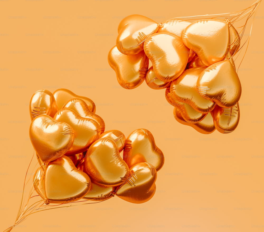 un mazzo di palloncini dorati a forma di cuore che fluttuano nell'aria