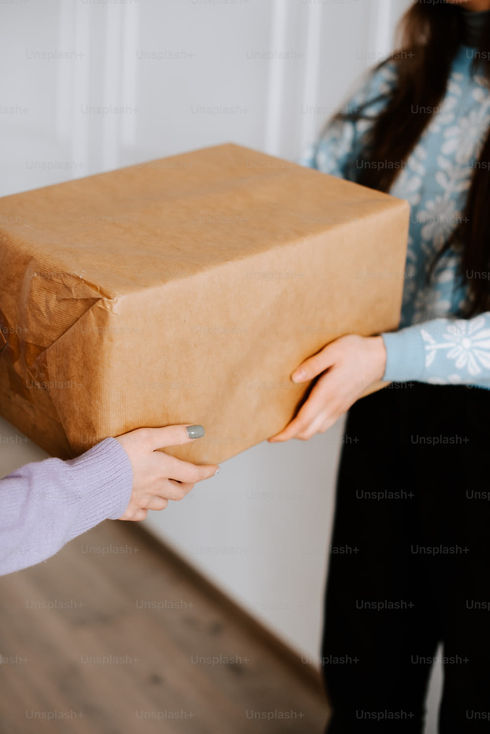 Una mujer sosteniendo una caja marrón con un mango marrón