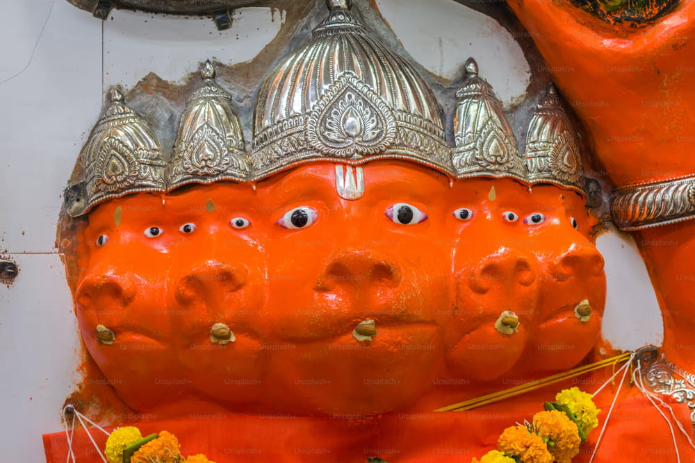 a close up of a statue of a person wearing an orange outfit