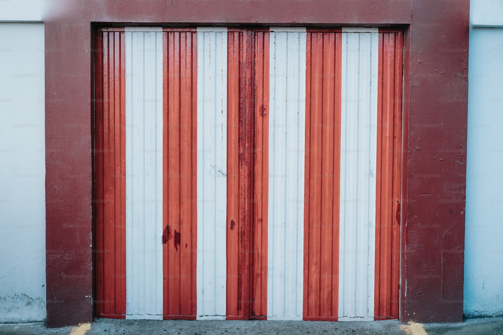 a red and white striped garage door on a building