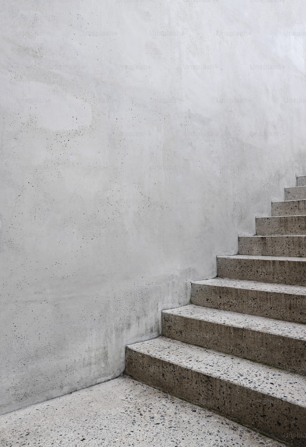 a set of concrete stairs leading up to a white wall