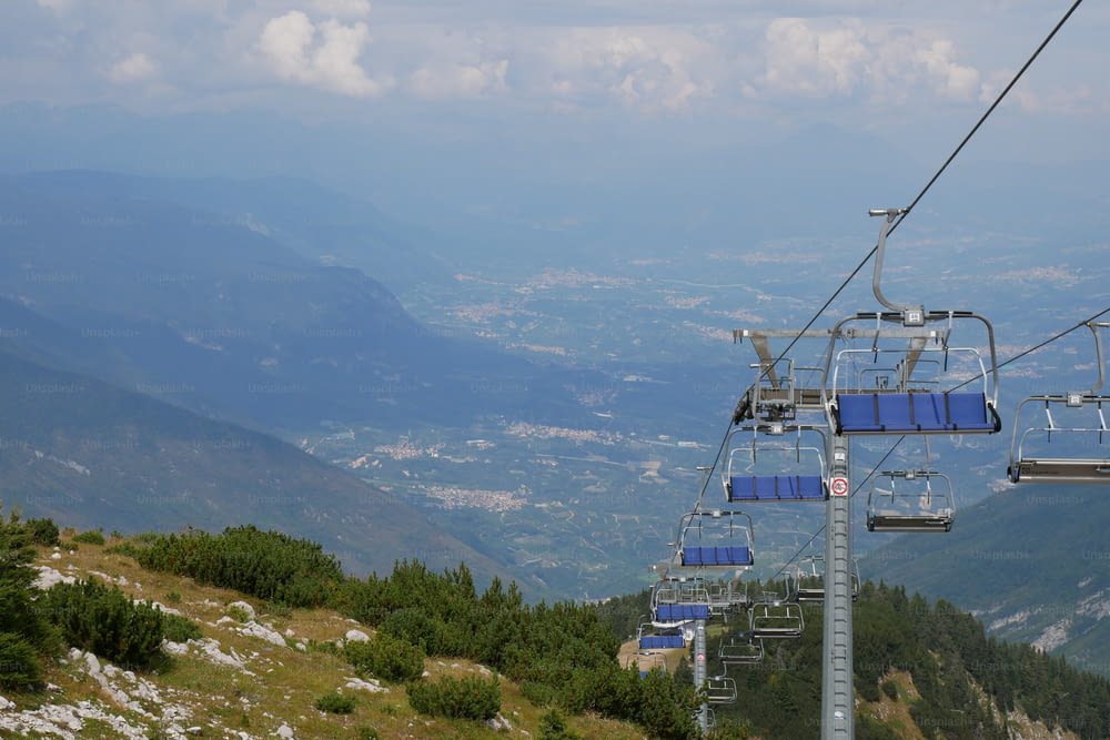 a ski lift going up a mountain with a view of the valley below