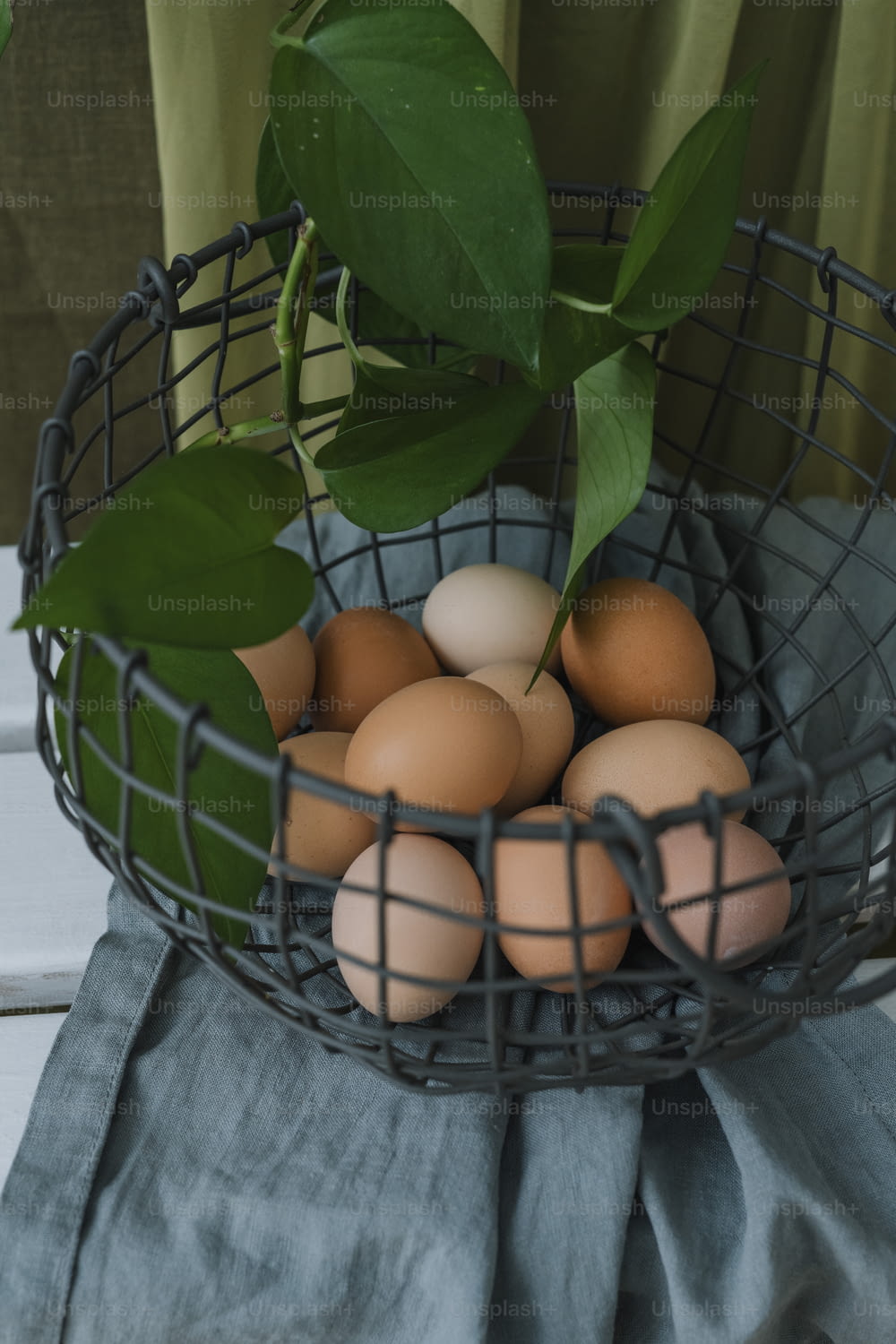 a metal basket filled with eggs on top of a table