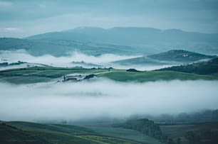 遠くになだらかな丘がある霧の谷