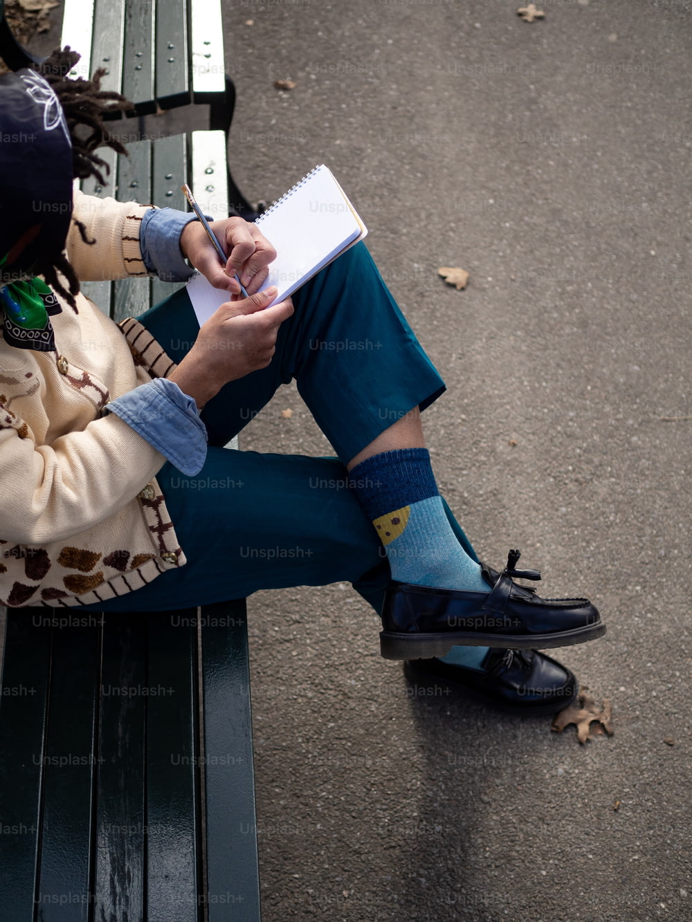 une personne assise sur un banc écrivant sur un morceau de papier