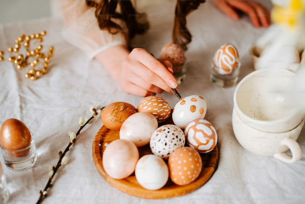 a woman is decor eggs on a table
