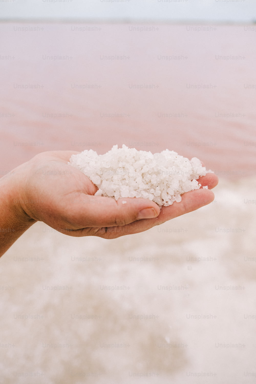 a person holding a handful of salt in their hand