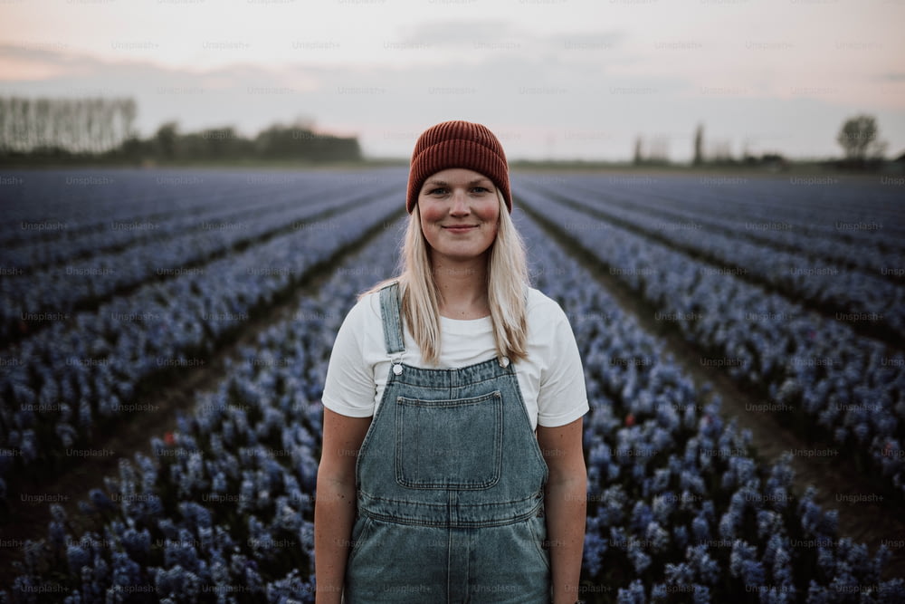 a woman standing in a field of blue flowers
