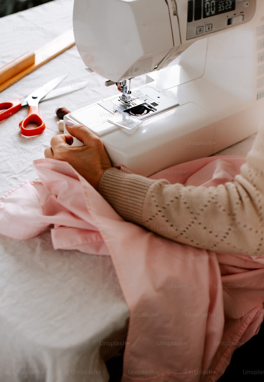 uma mulher que usa uma máquina de costura em uma mesa