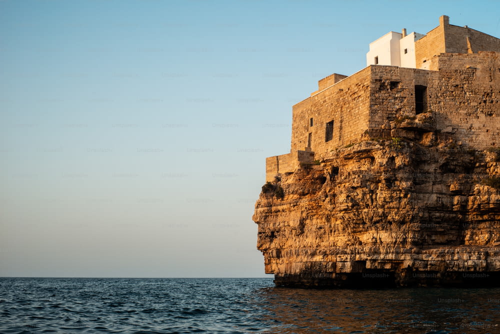 海の隣の崖の上に座�っている大きな石造りの建物
