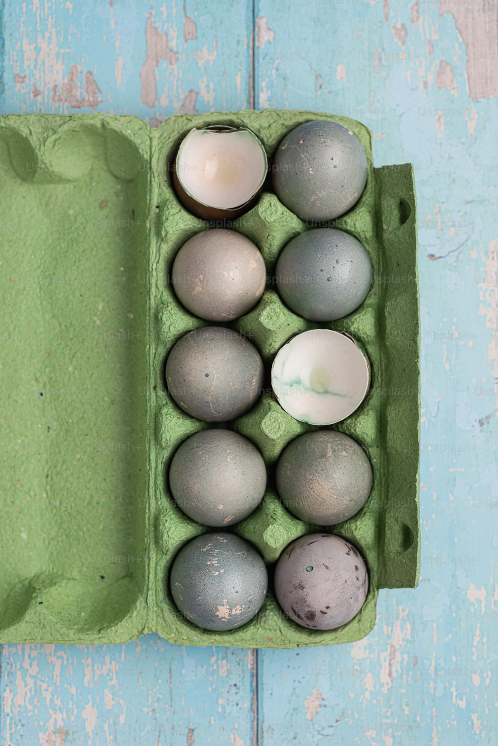 a carton of eggs on a blue wooden table