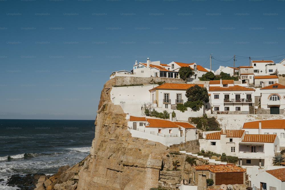 a view of a village on a cliff near the ocean