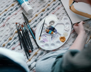 a person is painting on a white plate
