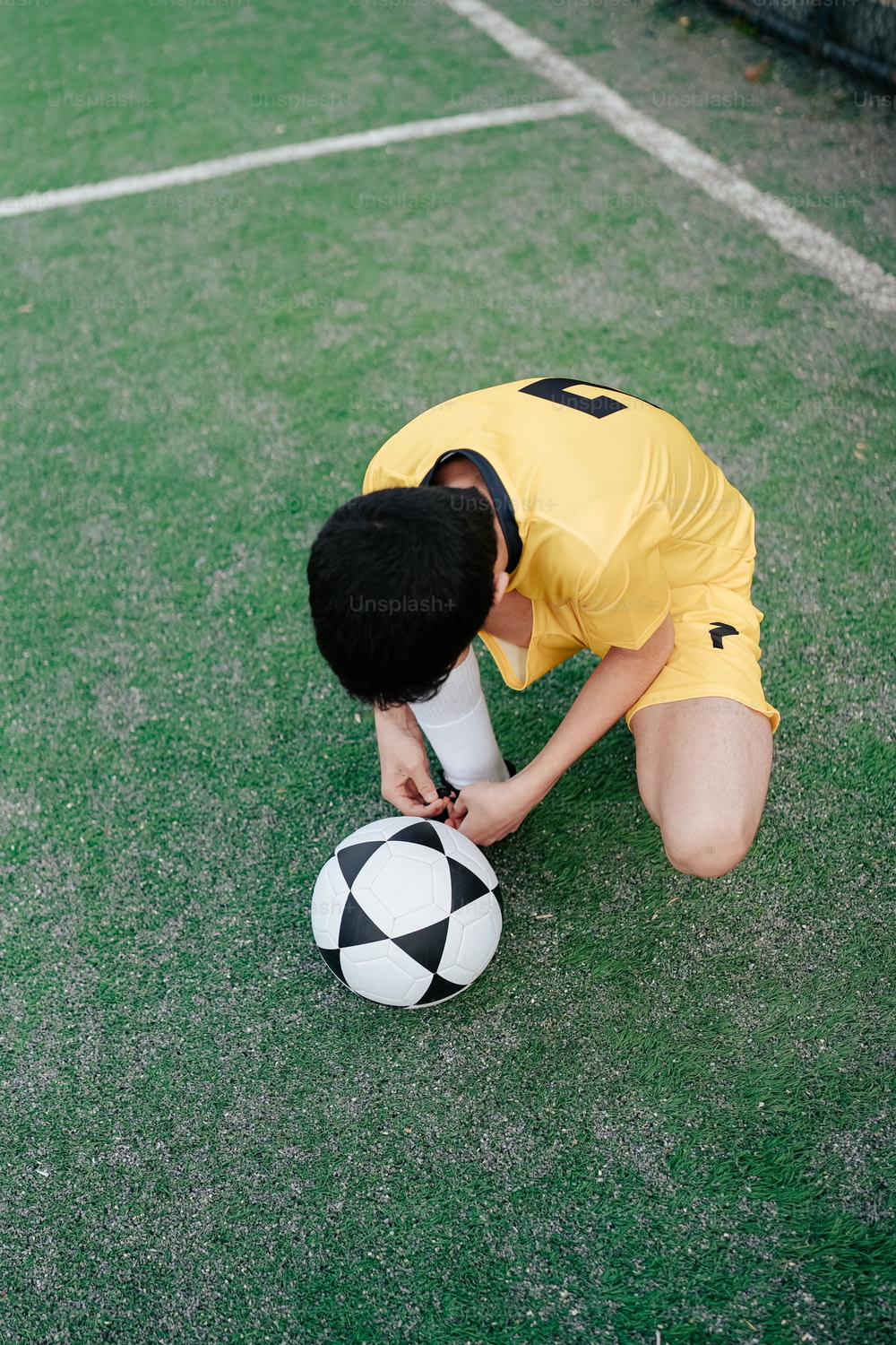a man kneeling down next to a soccer ball