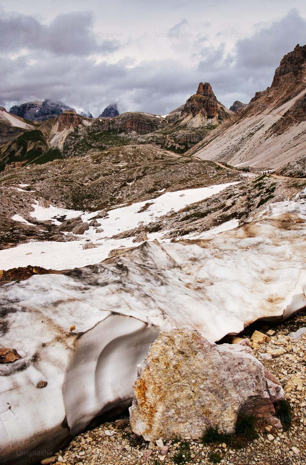 Eine Berglandschaft mit Schnee auf dem Boden und Felsen auf dem Boden