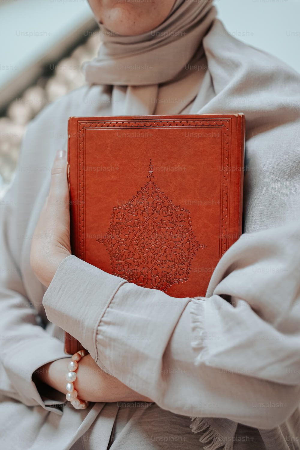 Une femme en hijab tenant un livre