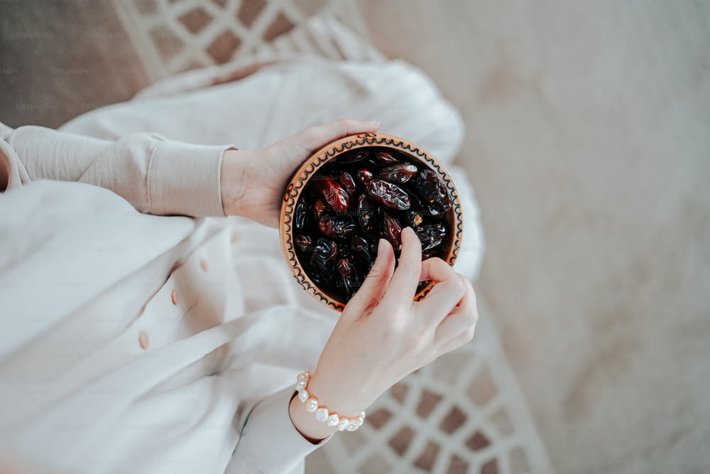 Une femme tenant un bol de raisins secs dans ses mains
