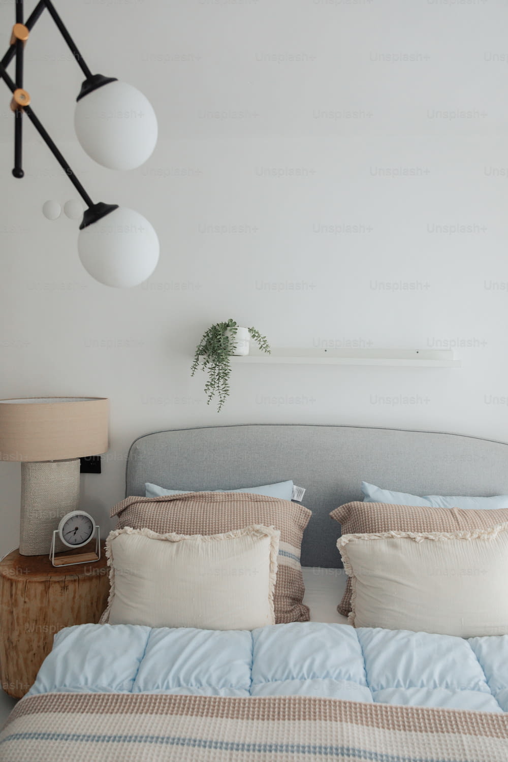 a bedroom with a bed, nightstand, and hanging lights