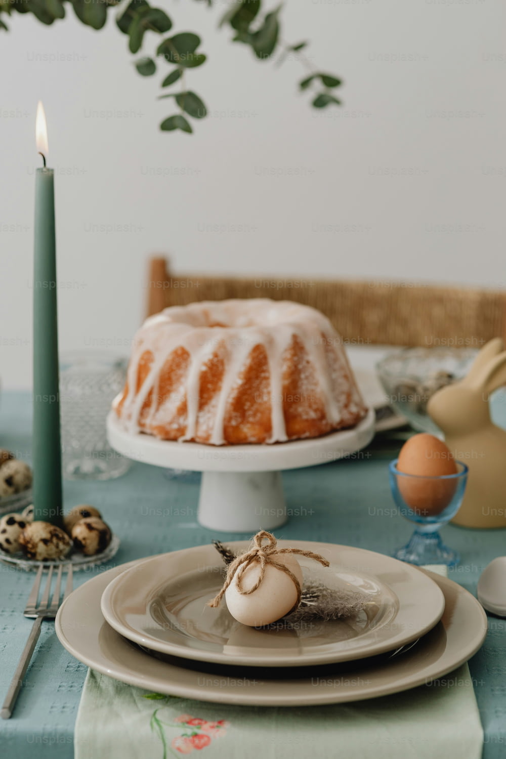 a table topped with a bundt cake next to a candle