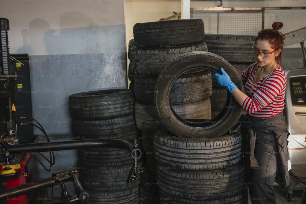 Una donna che lavora su un pneumatico in un garage