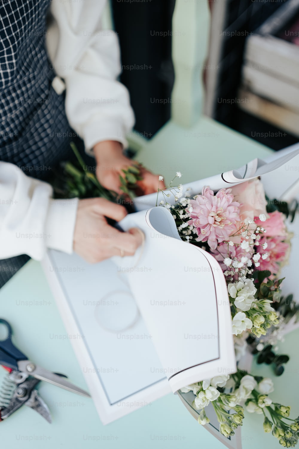 a person cutting a bouquet of flowers with scissors