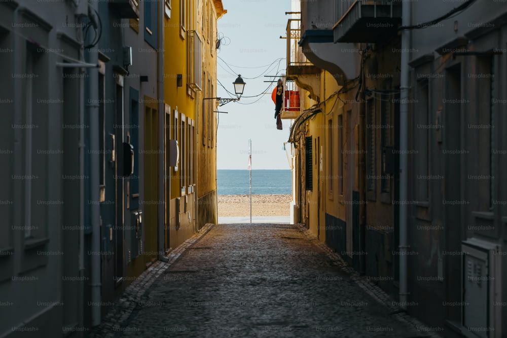 a narrow alley way leading to a beach