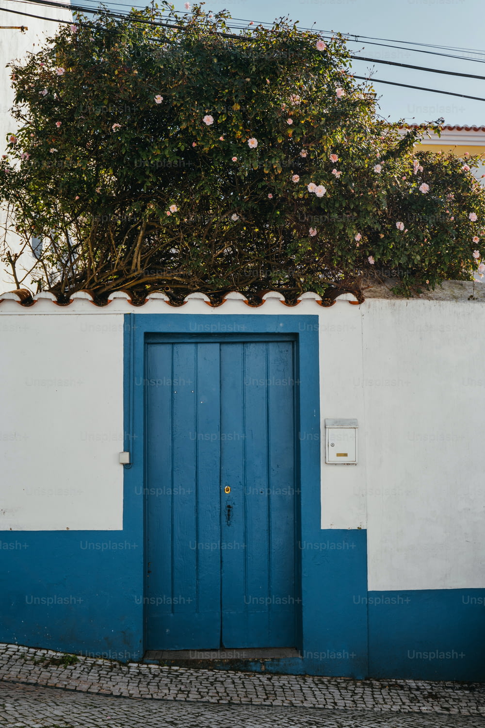 Un bâtiment bleu et blanc avec une porte bleue