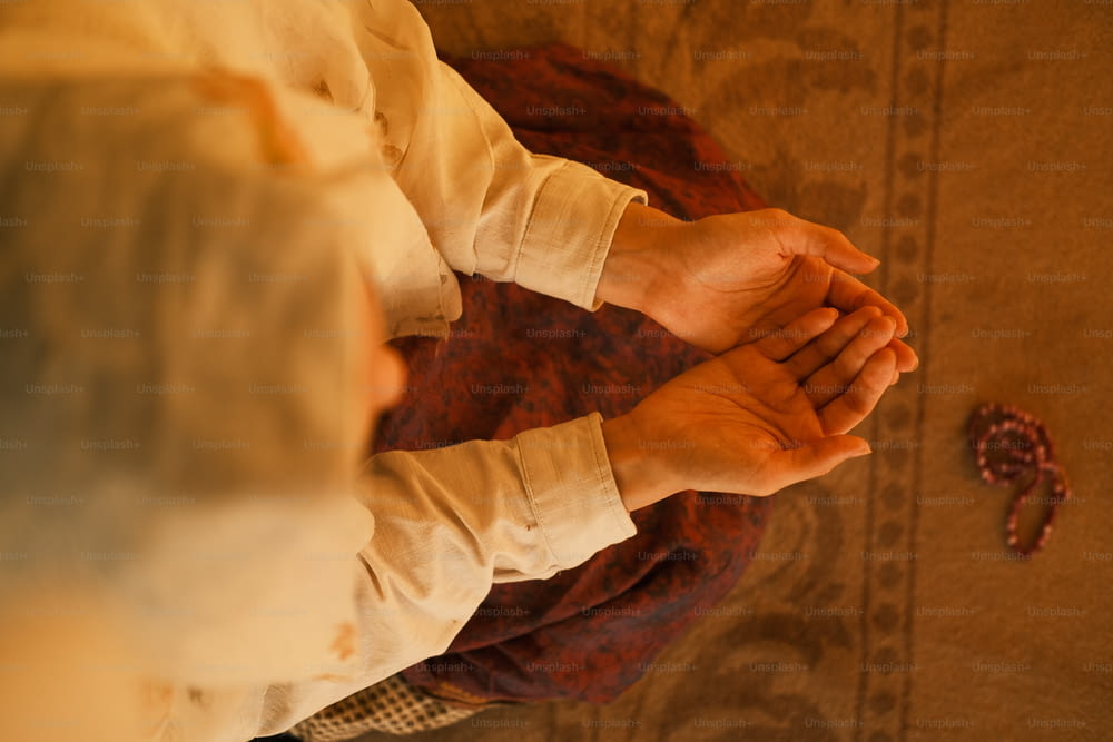 eine Person, die ihre Hände im Gebet zusammenhält