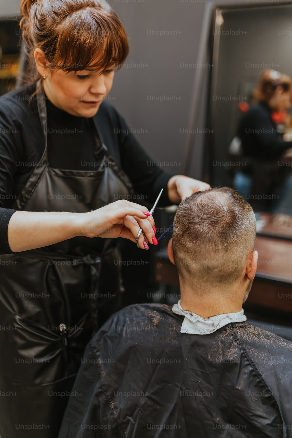 a woman cutting a mans hair in a salon