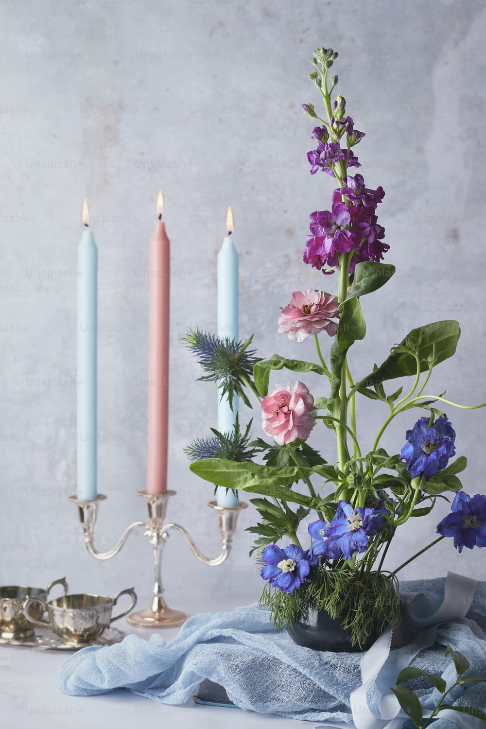 a vase filled with flowers next to two candles